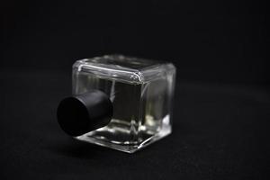 A glass perfume bottle on a black background. A bottle of perfume in close-up. Perfumery. photo