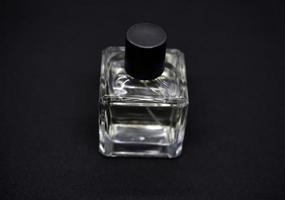 A glass perfume bottle on a black background. A bottle of perfume in close-up. Perfumery. photo