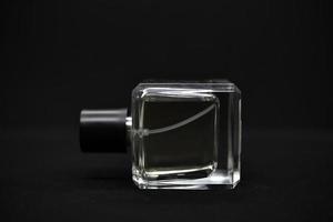 A glass perfume bottle on a black background. A bottle of perfume in close-up. Perfumery. photo