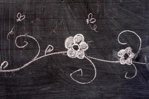 Flower Hand Drawing in Doodle Style on Chalkboard. photo