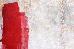 Stained Red Painting on Grunge Concrete Wall Texture Background. photo