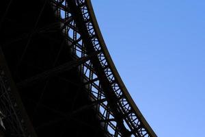 cerca arriba curva de eiffel torre con azul cielo antecedentes. foto