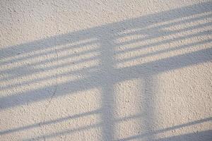 Fence Shadow on Surface of Stucco Wall. photo