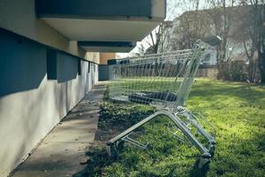 a shopping trolley next to an apartment building photo