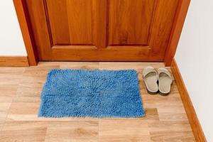 blue door mat and footwear with close door photo