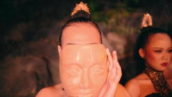 a beautiful Asian woman is wearing a bamboo mask for a dance performance at a festival held in the village video