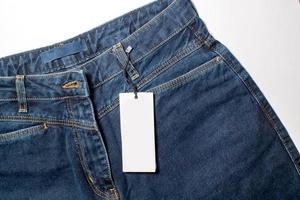 The layout of a white business card in a denim pocket is a fashionable background, a place to copy photo