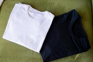 A black and white T-shirt lies folded on the table photo