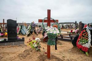 Grave crosses with wreaths in the cemetery on the sand photo