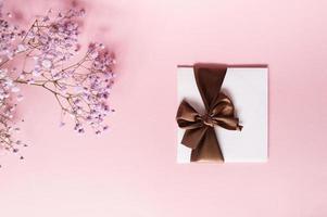 A gift envelope with a bow, with an empty copy space on a pink background. Flat stands. gypsophila flowers photo