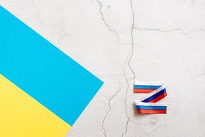 The Ukrainian flag and the letter Z from the Russian flag on a plaster background. The concept of the war between Russia and Ukraine photo