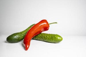 Fresco Pepino y rojo pimienta aislado en blanco antecedentes sabroso y sano comida plano lado ver foto