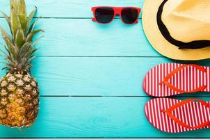 Summer accessories for modern woman on her vacation. Top view. Blue wooden background with copy space. photo