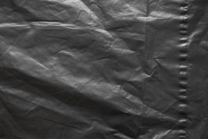 transparent plastic bag wrap overlay texture on black background photo