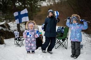 Three finnish children with Finland flags on a nice winter day. Nordic Scandinavian people. photo
