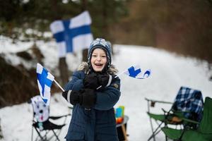 Finnish boy with Finland flags on a nice winter day. Nordic Scandinavian people. photo