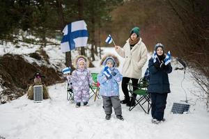 finlandés madre y niños con Finlandia banderas en un bonito invierno día. nórdico escandinavo gente. foto