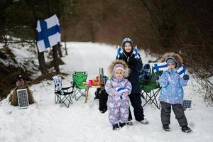 Tres finlandés niños con Finlandia banderas en un bonito invierno día. nórdico escandinavo gente. foto