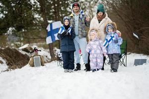 finlandés familia con Finlandia banderas en un bonito invierno día. nórdico escandinavo gente. foto