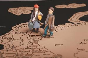 Miniature people with traveling concepts. Miniature traveler with baggage walking on the world map photo