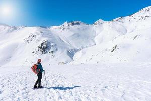 woman in mountain gear contemplates the snowy mountain scenery photo