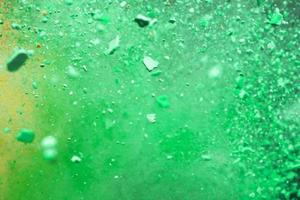 A burst of colorful yellow-green particles. Abstract splash background with selective focus photo