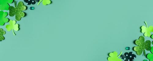 St. Patrick's Day banner. Paper clover leaves on colored background with copy space photo