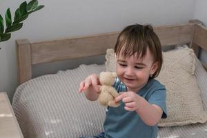 Little boy playing with a teddy bear. Child playing with his favorite toy. photo