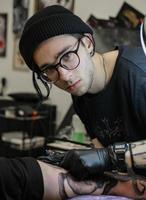 profesional tatuaje artista telas un tatuaje en el del hombre mano. tatuaje artista a trabajar. tatuaje creación proceso. Arte y creatividad foto