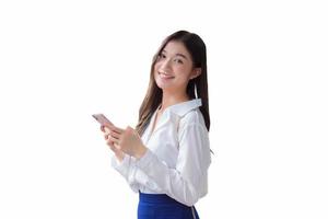 Young Asian business beautiful woman stands confidently while uses her smartphone to send messages to someone isolated on white background. photo