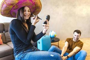 young womanwearing sombrero is finishing her make up before leaving photo