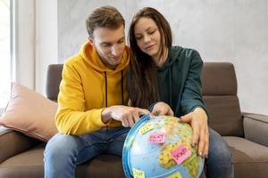 young couple is planning the next trip by choosing the destination photo