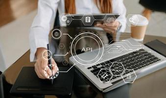 interfaz de programación de aplicaciones api, mujer que usa computadora portátil, tableta y teléfono inteligente con herramienta de desarrollo de software de icono de pantalla virtual api, tecnología y concepto de red. foto