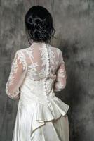 portrait of a girl in a wedding dress on a gray background photo