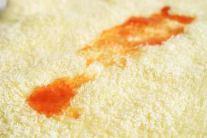 Dirty spicy sauce stain on cloth to wash with washing powder, cleaning housework concept. photo