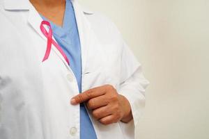 Asian woman doctor with pink ribbon, World Breast Cancer Day at October. photo