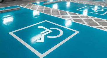 Car parking lot reserved for handicapped driver in supermarket or shopping mall. Car parking space for disabled people. Wheelchair sign paint on parking area. Blue and white handicapped parking lot. photo