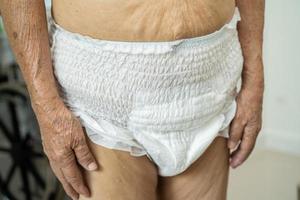 asiático mayor mujer paciente vistiendo incontinencia pañal en hospital, sano fuerte médico concepto. foto