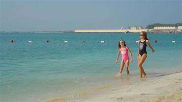 les enfants s'amusent beaucoup sur la plage tropicale en jouant ensemble video