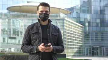 Mens vervelend een masker Aan een achtergrond van een modern gebouw, video