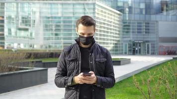 Man wearing a mask on a background of a modern building, video