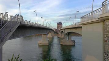 Drone video of a vertical movement upwards between the lanes of the Nibelungen Bridge in Worms with a moving car and view of the Nibelung Gate