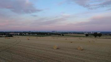 Drohne Film fliegend Über landwirtschaftlich Feld im Abend Zeit mit Frankfurt Horizont im Hintergrund video