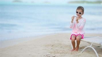 Happy little girl with toy airplane in hands on white beach video