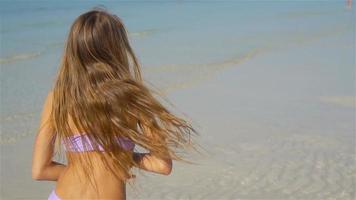 förtjusande Lycklig liten flicka ha roligt på strand semester video