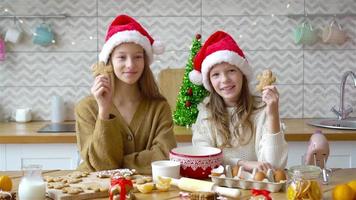 liten flickor framställning jul pepparkaka hus på öppen spis i dekorerad levande rum. video