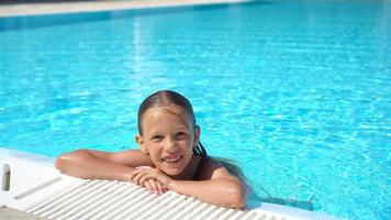 Adorable little girl swimming at outdoor swimming pool video