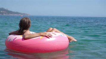 adorable fille sur un matelas pneumatique gonflable dans la mer video