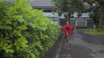 kinesisk barn med röd kostym spelar i de trädgård video