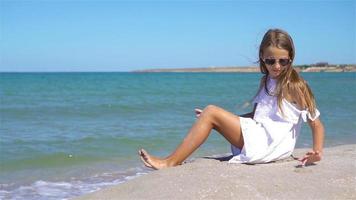 entzückendes kleines mädchen hat spaß am tropischen strand während des urlaubs video